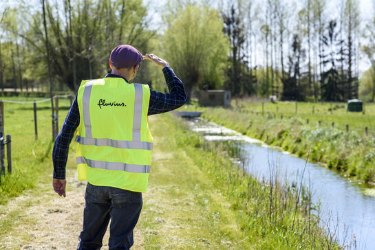 Climate and environment - climate adaptation Fluvius employee at a stream