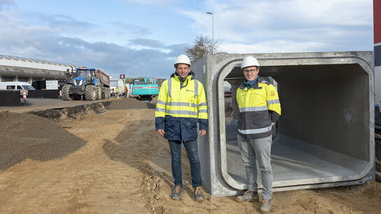 Fluvius medewerkers voor een rioleringsbuis