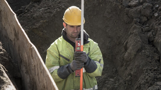 Fluvius is building a sewerage network taking climate change into account Fluvius employee at work installing a sewerage system