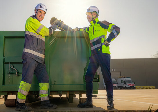 Circulair materiaalgebruik Medewerkers van Fluvius recycleren materiaal in een container