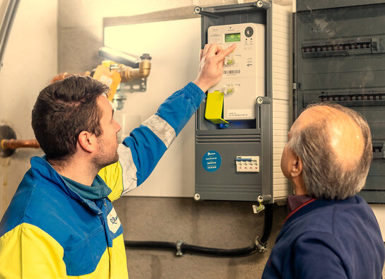 Technieker van Fluvius geeft uitleg over de digitale meter aan een klant