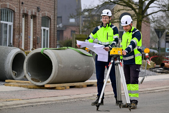 Fluvius technicians carry out measurements and review plans at a sewer worksite as part of the investment plan for future-proof water networks.