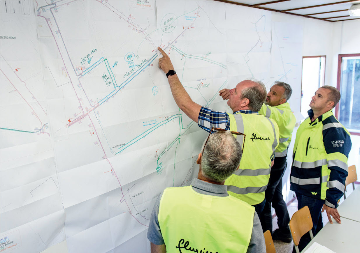 Investeringsplannen Medewerkers van Fluvius bekijken een plan aan de muur