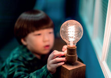 Résoudre les problèmes de tension Un enfant regarde une ampoule électrique