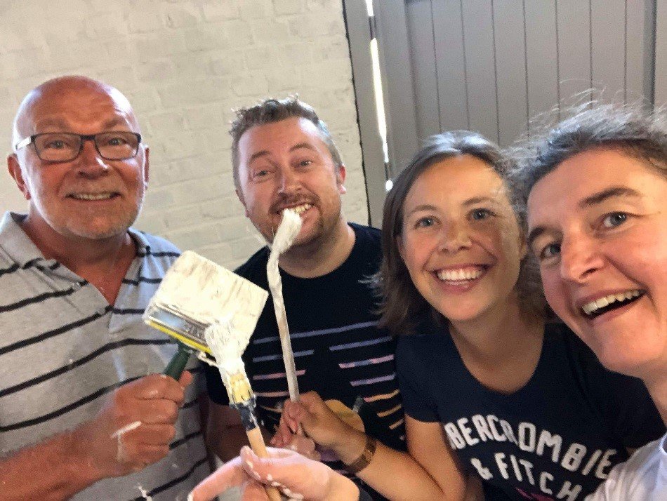 Blije gezichten bij vrijwilligers van Fluvius-klusteam Een lachend klusteam van Fluvius – Goede doelen staat klaar om te schilderen en poseert met veel plezier voor de foto.